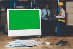 Computer with green screen display in warehouse storage room . Delivery and transportation software concept .