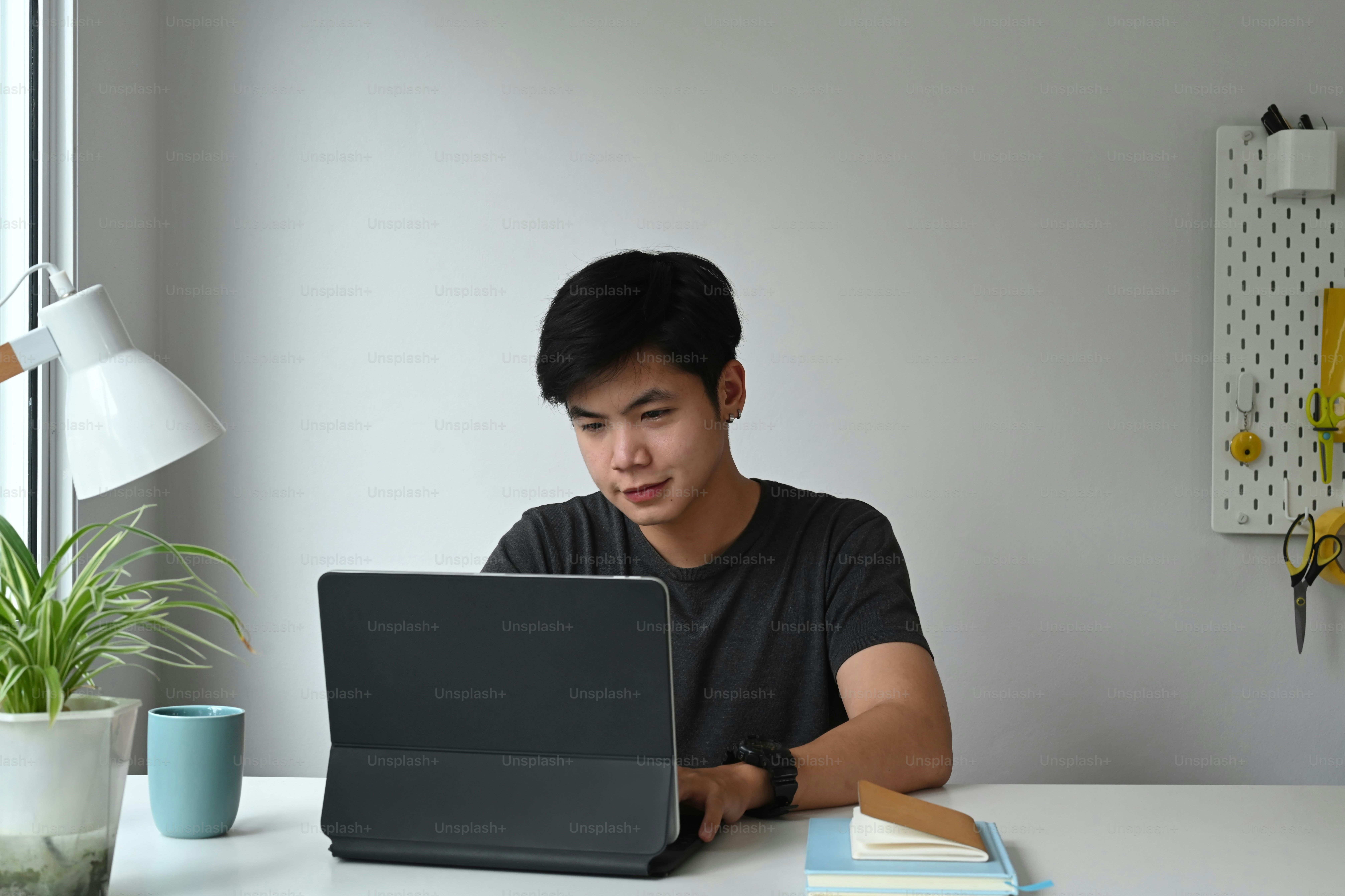 Tampilan depan seorang desainer grafis sedang mengerjakan tablet komputer di ruang kerja kreatifnya.