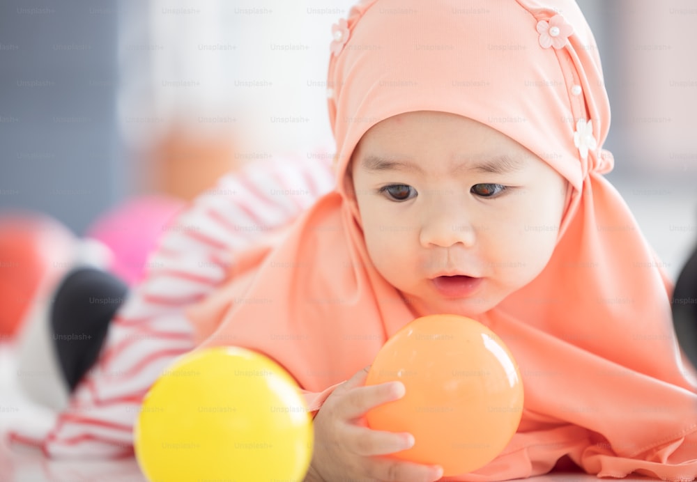 Muslim Baby spielt mit buntem Spielzeug im Wohnzimmer
