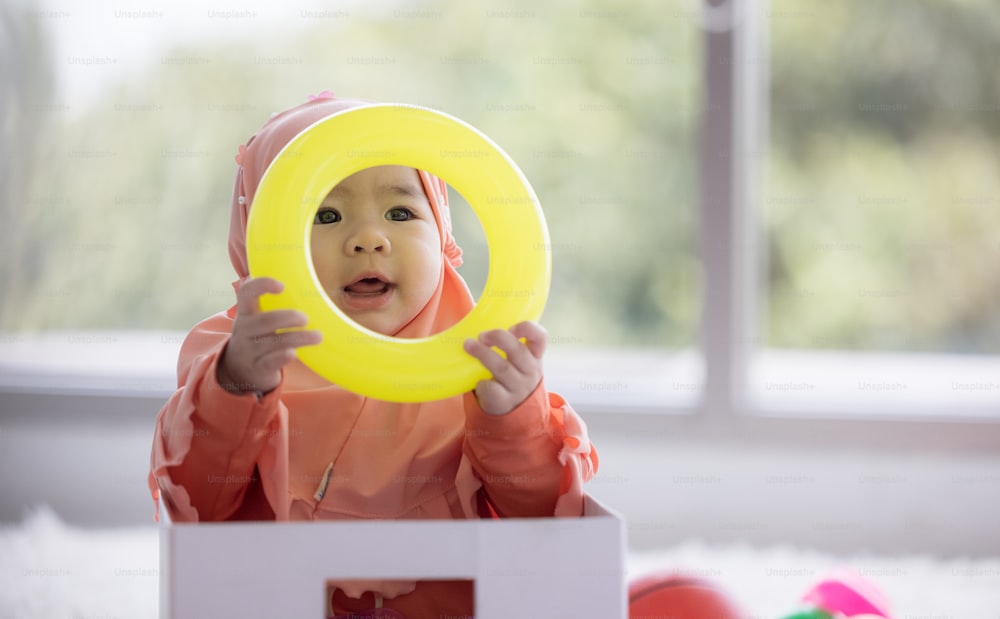 Muslim Baby joue avec des jouets colorés dans le salon