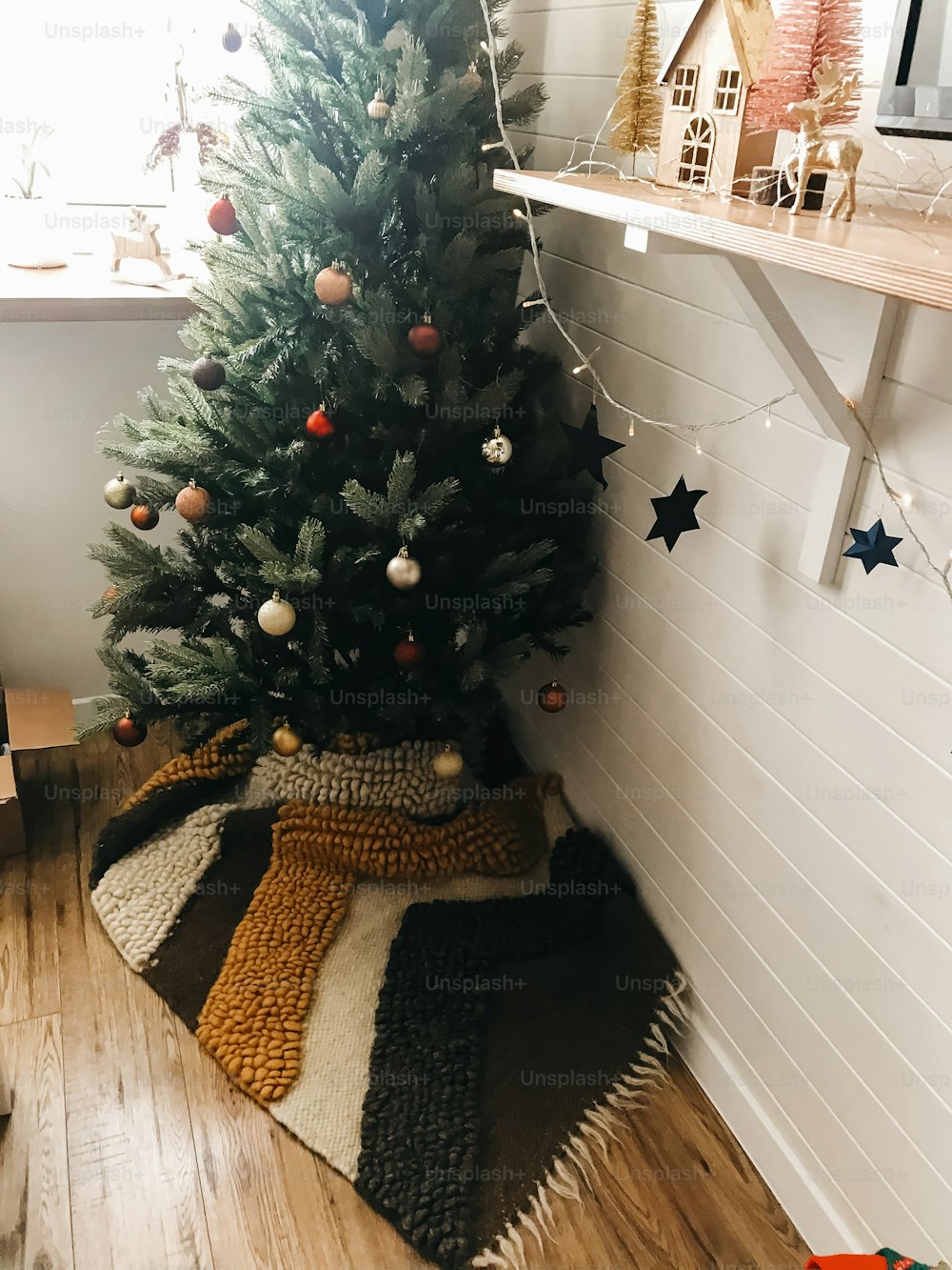 축제로 장식된 보호 방에 빨간색과 금색 싸구려가 있는 전통적인 크리스마스 트리. 겨울 방학을 위해 집을 준비합니다. 즐거운 휴일과 메리 크리스마스!