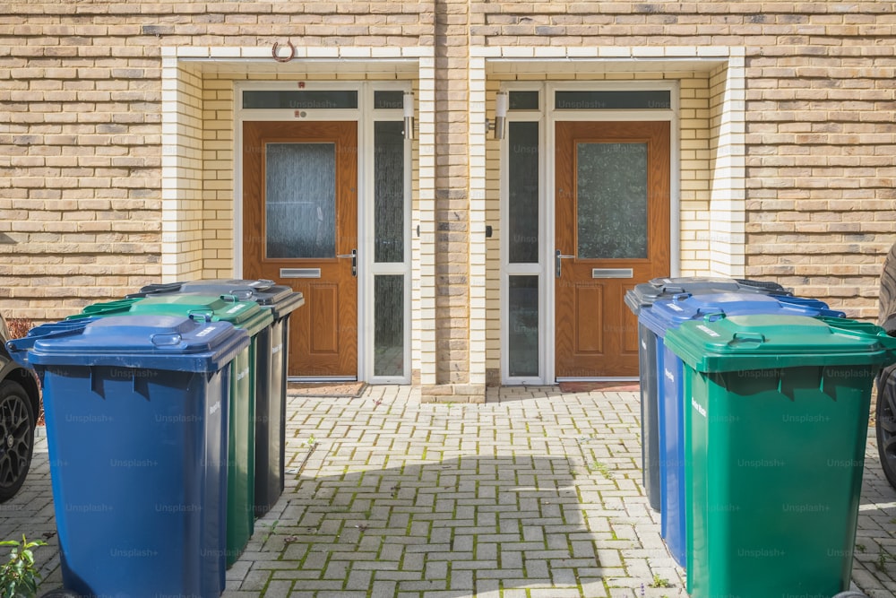 Wheelie bins outside the front doors, labelled for recycling, garden waste and refuse waste at the Grahame Park Estate in London