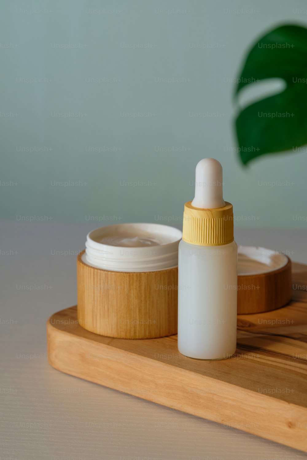 Set de cosmética natural. Crema hidratante en tarro de bambú ecológico y sérum en frasco cuentagotas. Diseño de empaque de productos orgánicos para el cuidado de la piel.