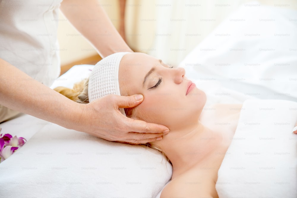 Caucasian woman resting on massage bed and get facial spa  treatment with essential oil from professional therapist at beauty salon