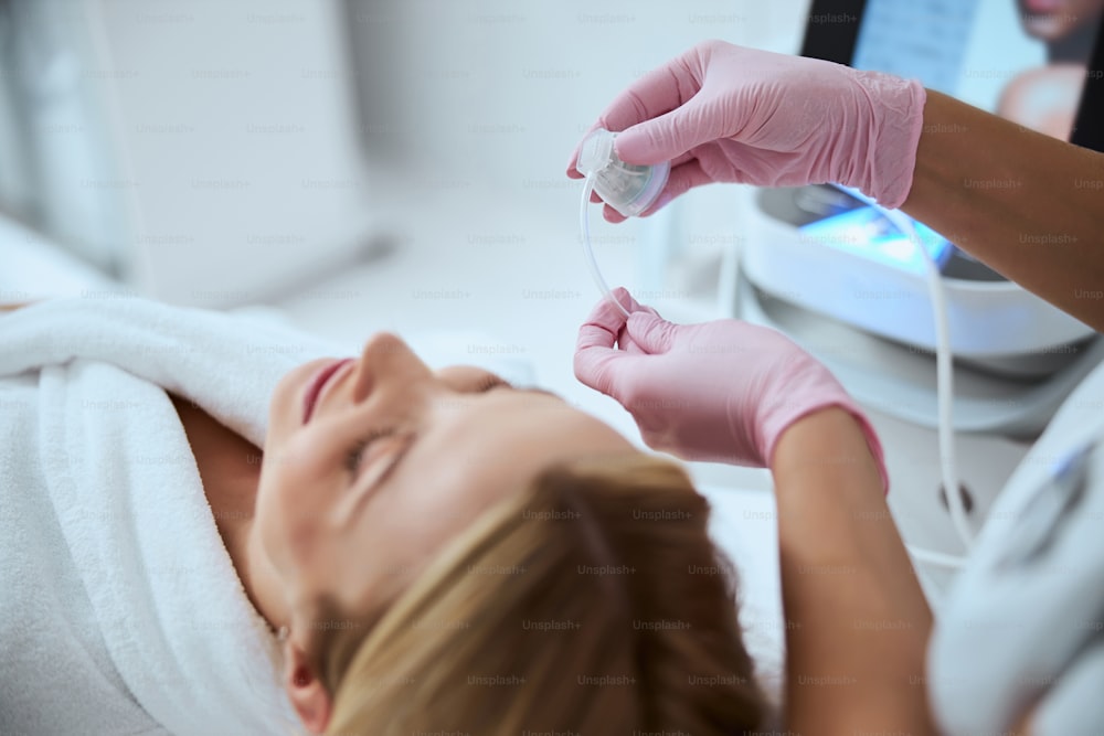 Photo recadrée d’une dermatologue préparant une jeune patiente pour une intervention cosmétique