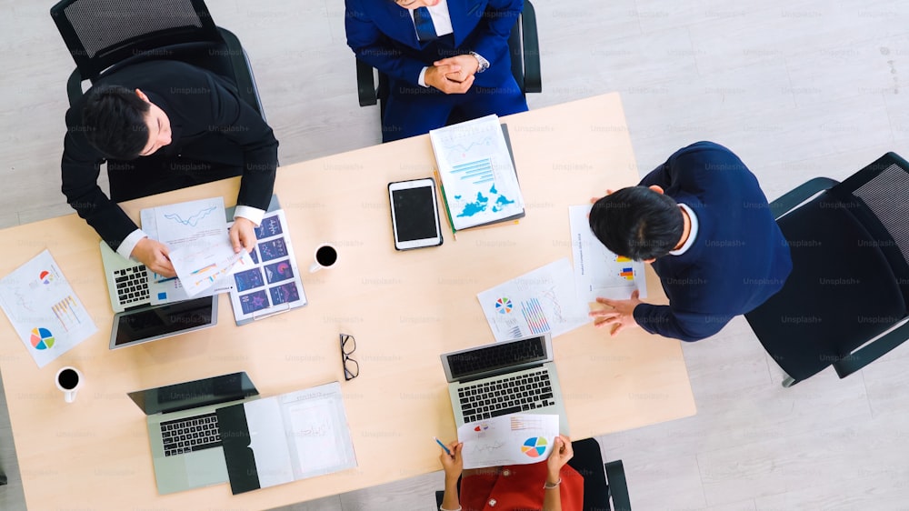 Business people group meeting shot from top view in office . Profession businesswomen, businessmen and office workers working in team conference with project planning document on meeting table .