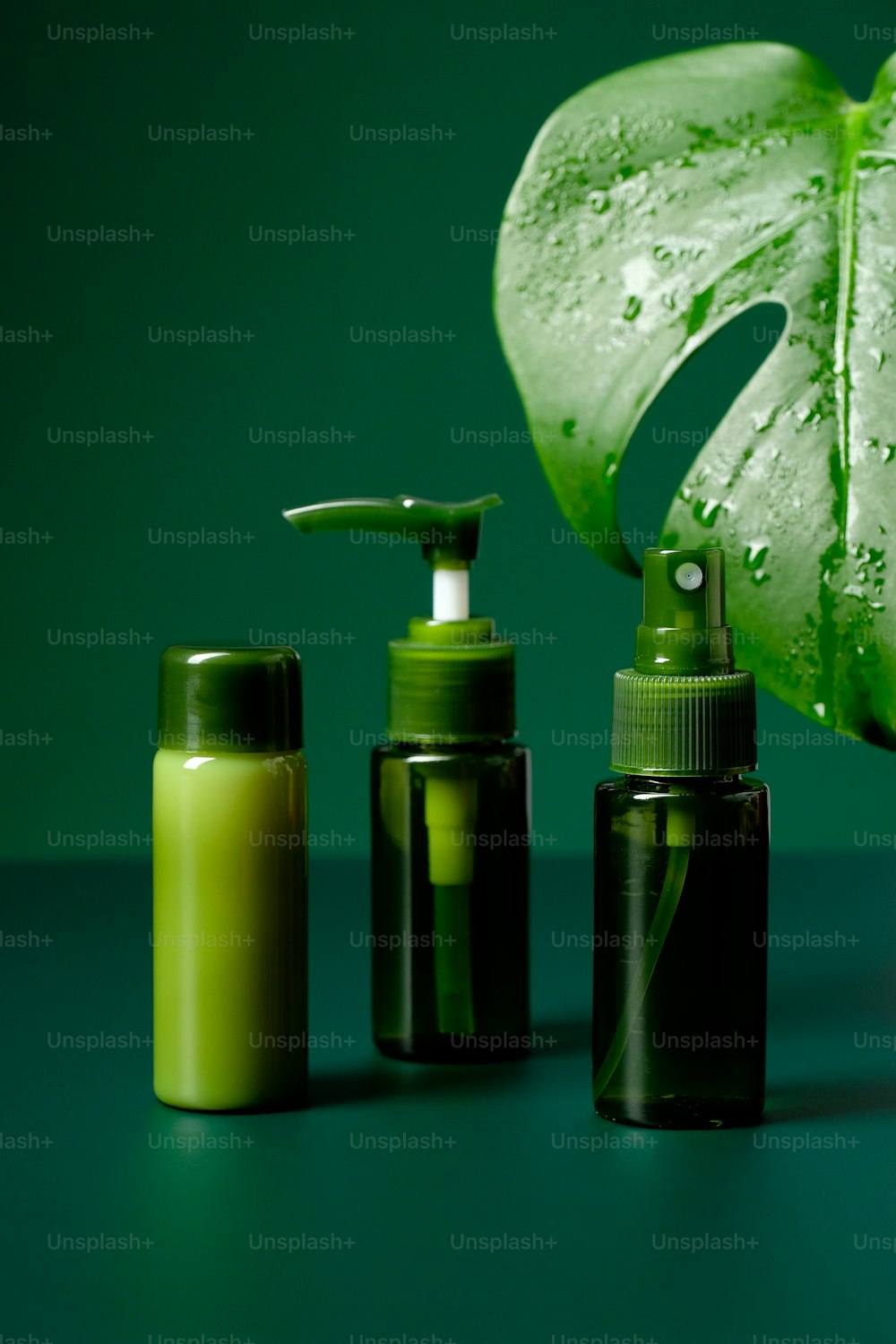 Composición con frascos de aceites esenciales orgánicos y lociones sobre fondo verde. Cosmética natural. Diseño de envases de productos de belleza.