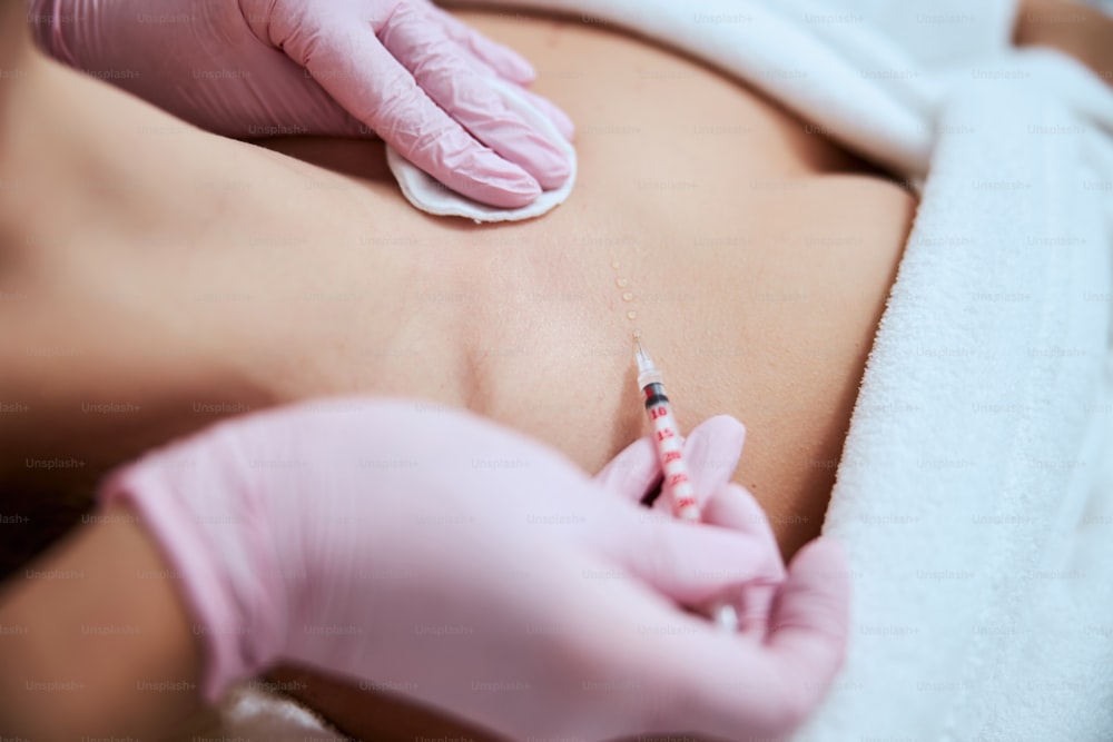 Cropped photo of a lady undergoing the decolletage rejuvenation treatment performed by a certified dermatologist