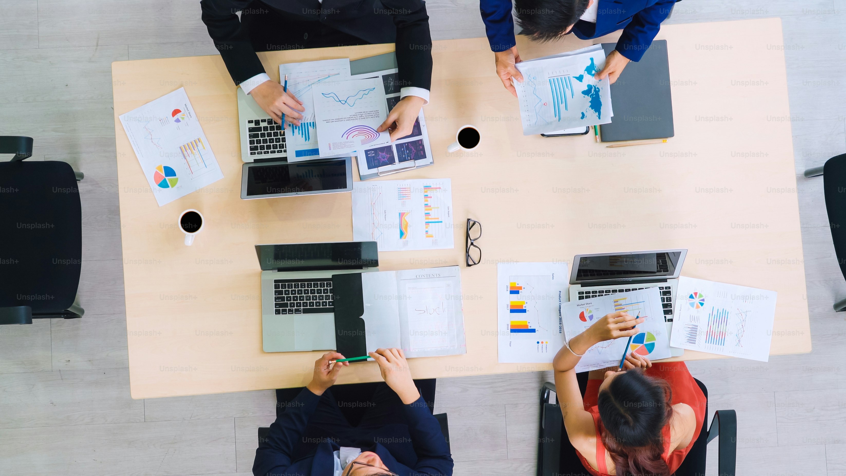 Reunión de grupo de gente de negocios disparada desde la vista superior en la oficina. Empresarias, hombres de negocios y oficinistas de la profesión que trabajan en equipo conferencia con documento de planificación de proyectos en la mesa de reuniones.