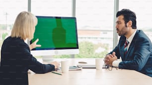 Pessoas de negócios na sala de conferências com tela verde chroma key TV ou computador na mesa do escritório. Grupo diversificado de empresário e empresária em reunião em videoconferência.