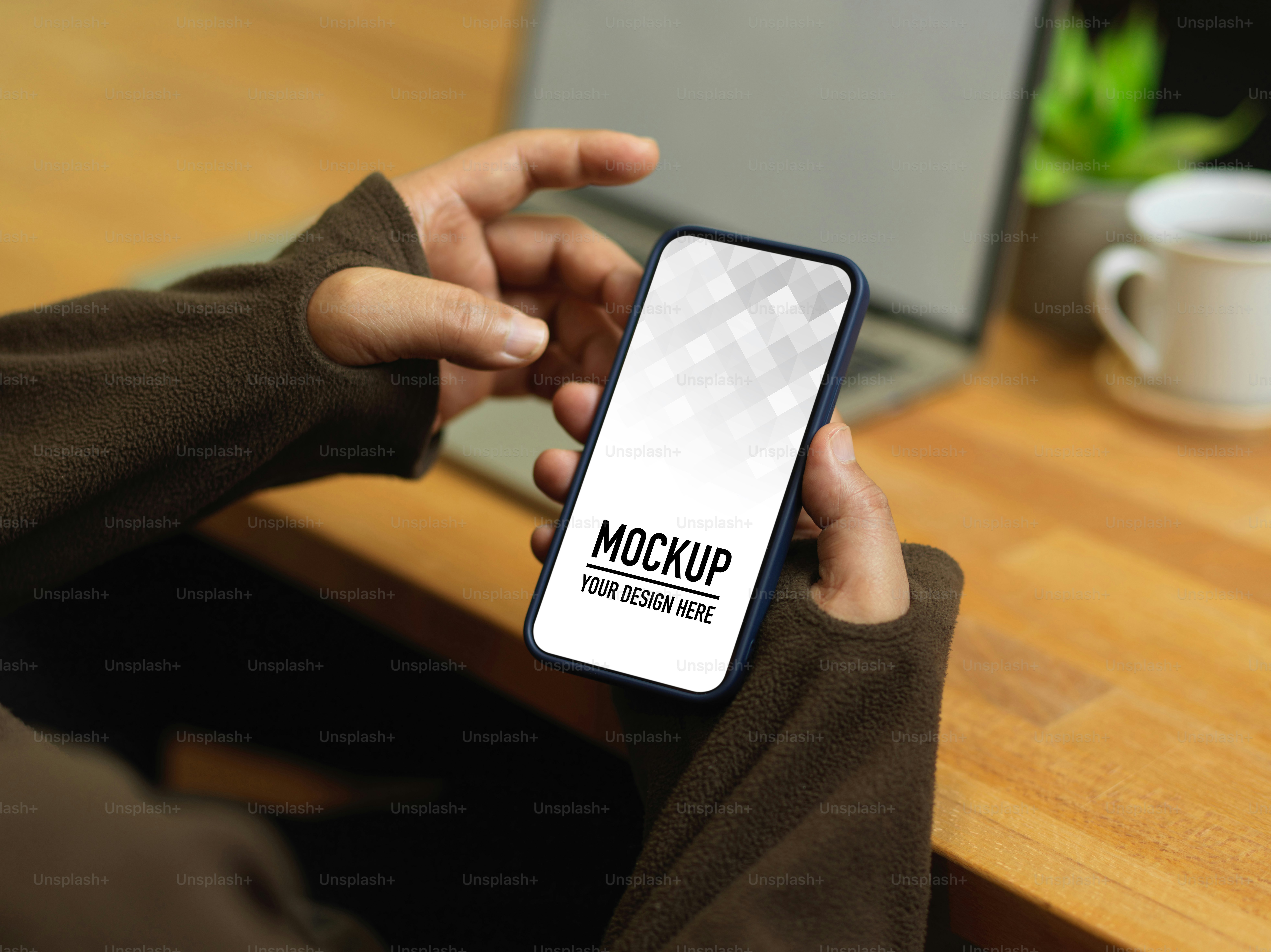 Colpo ritagliato di mani maschili che usano lo smartphone mentre sono seduti sul posto di lavoro, percorso di ritaglio