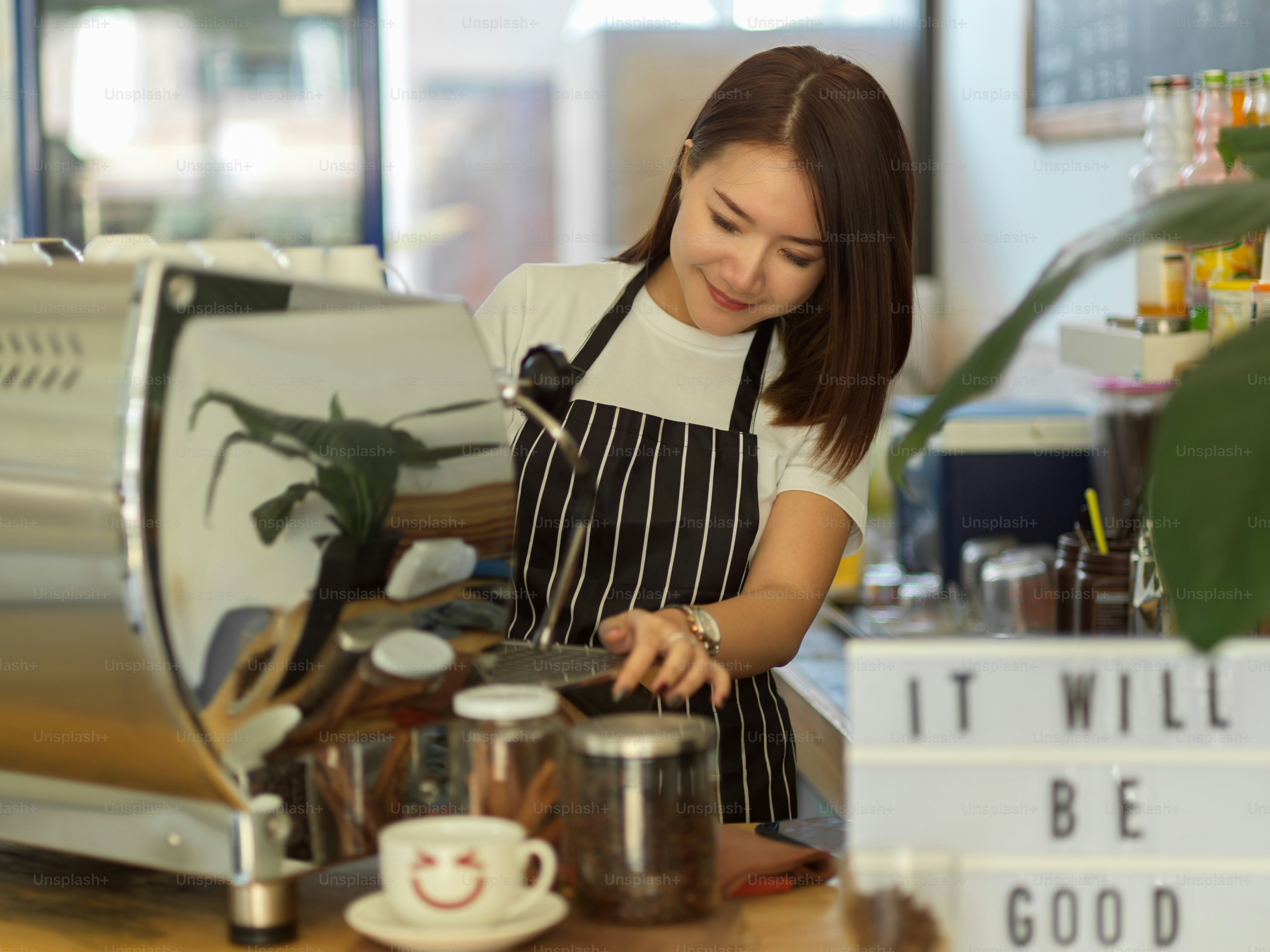 Retrato de una barista que trabaja con una máquina de café en una cafetería moderna