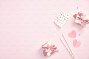 Concepto de feliz día de San Valentín. Tarjeta de felicitación plana, cajas de regalo y corazones de papel sobre fondo rosa. Vista superior con espacio de copia.