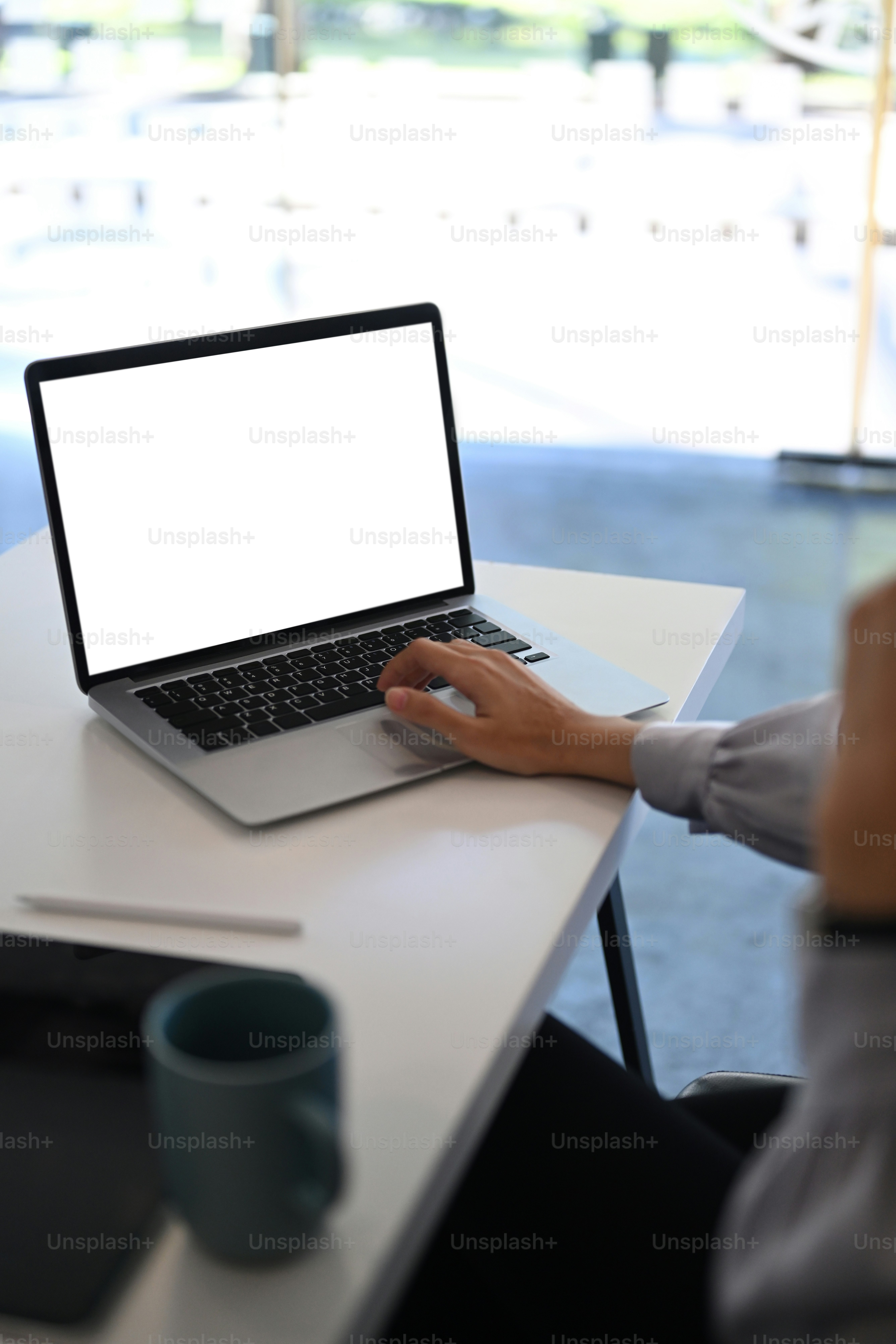 Foto cortada de uma jovem sentada no escritório moderno e usando informações de busca de laptop.