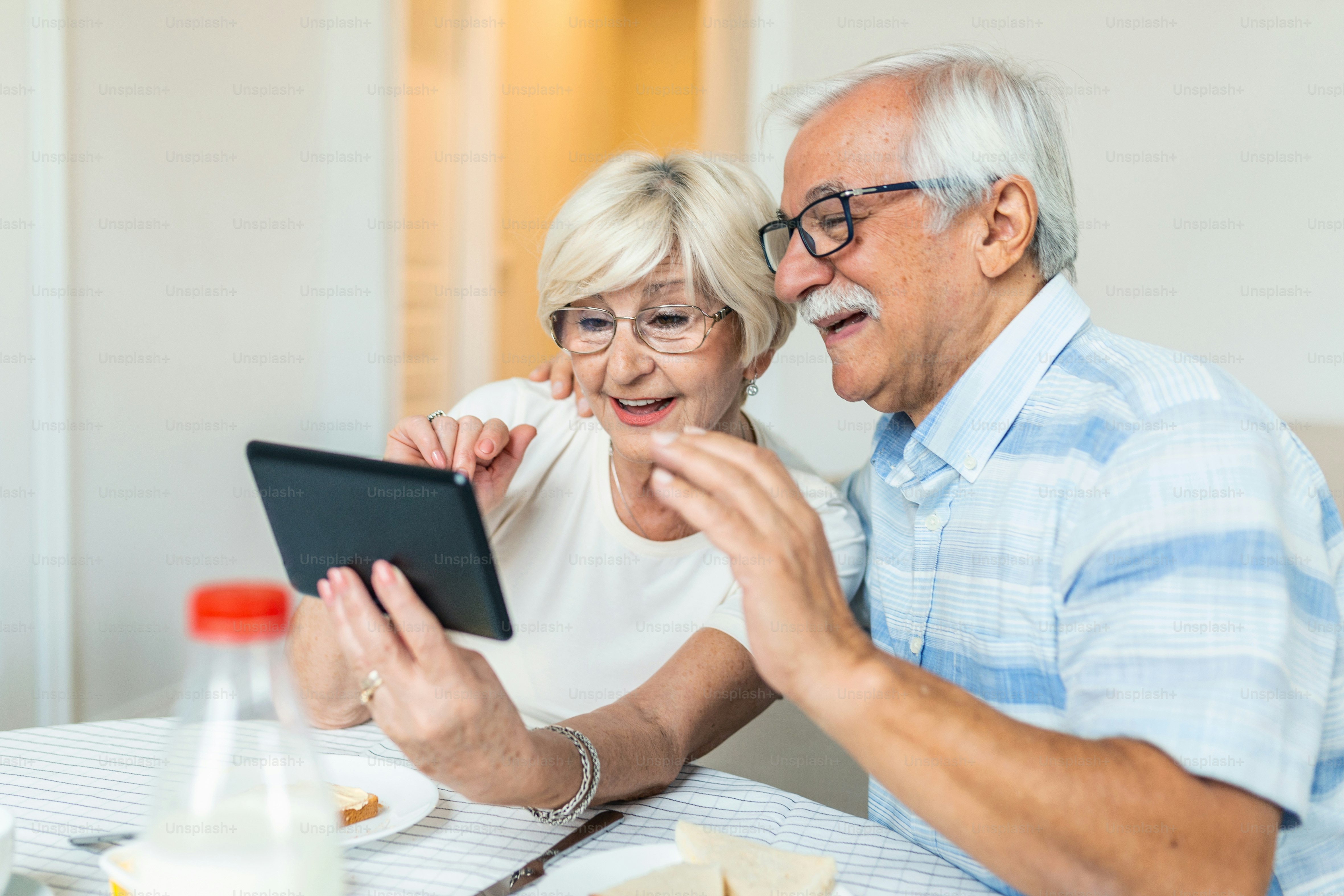 Seniorenpaar, das ein Selfie mit Tablet macht. Älteres Paar, das einen Videoanruf mit Freunden oder Familie über ein Tablet führt. Altes Paar spricht online per Videoverbindung auf dem Tablet.