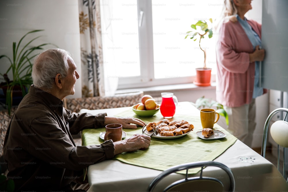 Pleasurable mood. Delighted happy couple having a meal together. Woman pulls something out of the fridge for breakfast