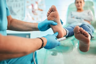 Close up portrait of woman on medical chair while pedicurist hand with special device doing peeling on feet in beauty center