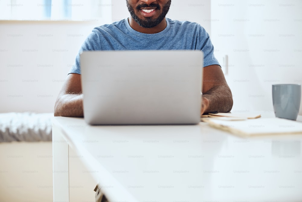Cropped photo of a multiethnic citizen performing his job at home on his computer