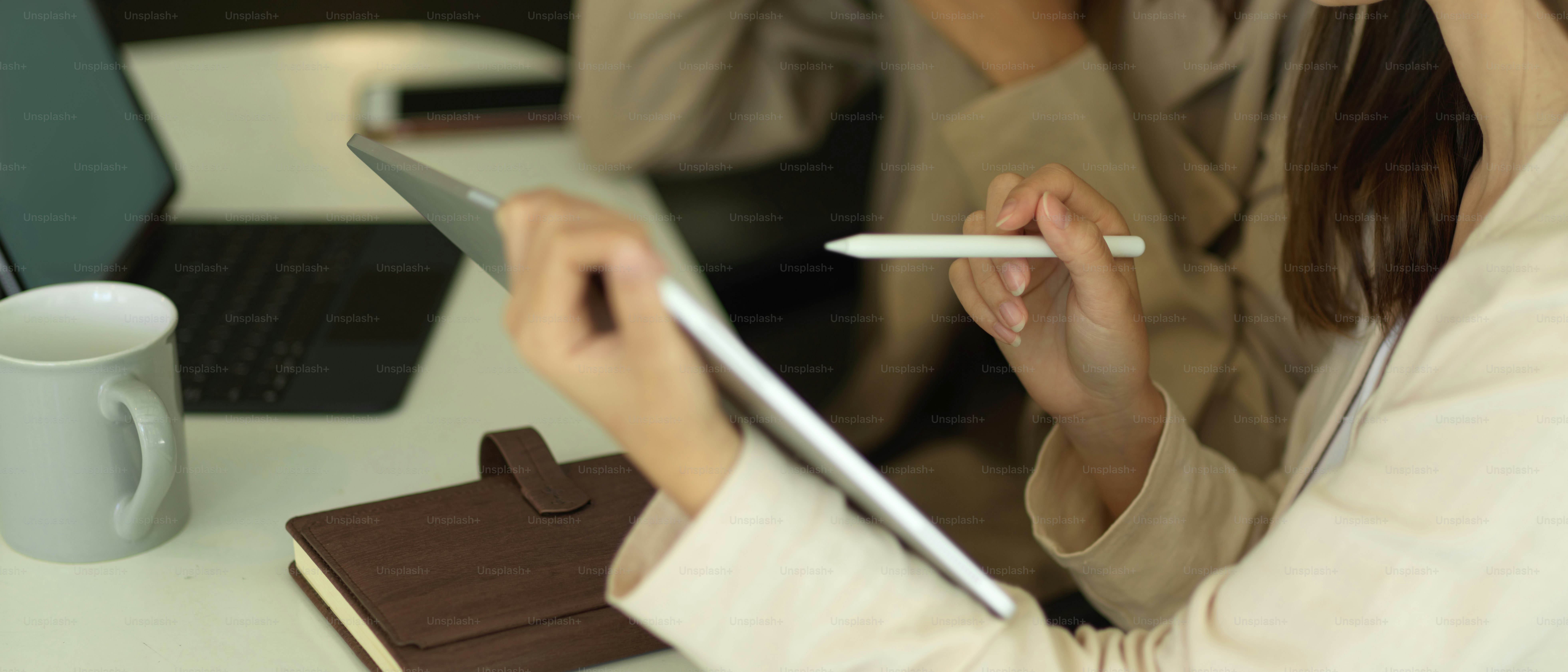 Vue latérale d’une femme d’affaires travaillant avec une tablette et parlant avec un collègue dans la salle de bureau