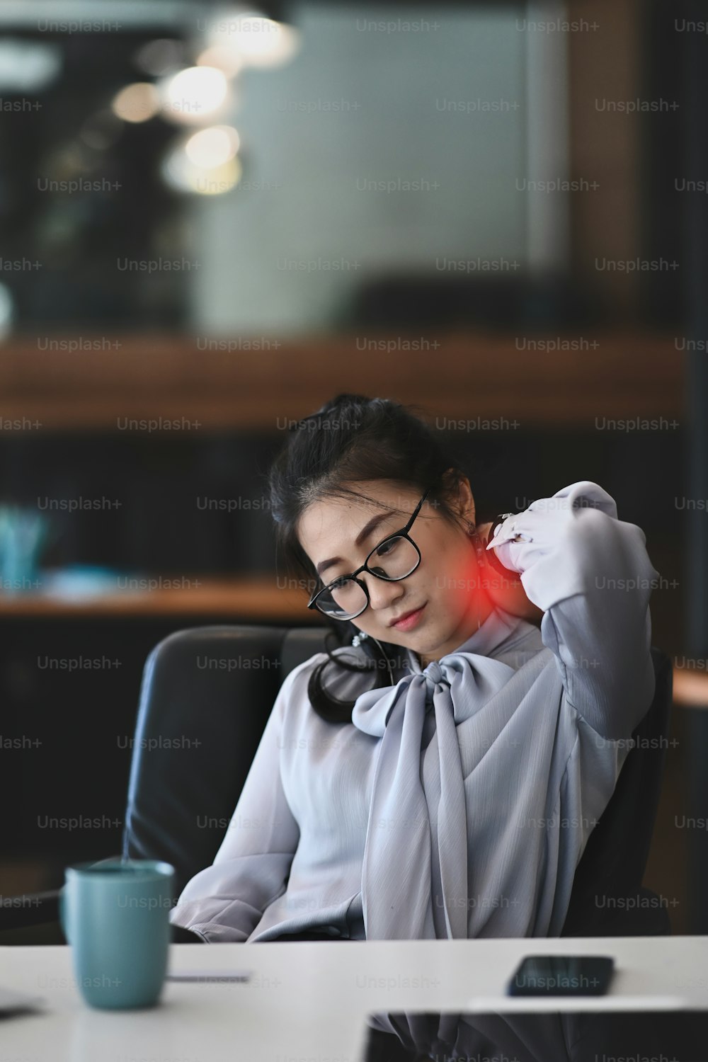 Stressed business woman suffering from shoulder and neck pain after work hard in office.