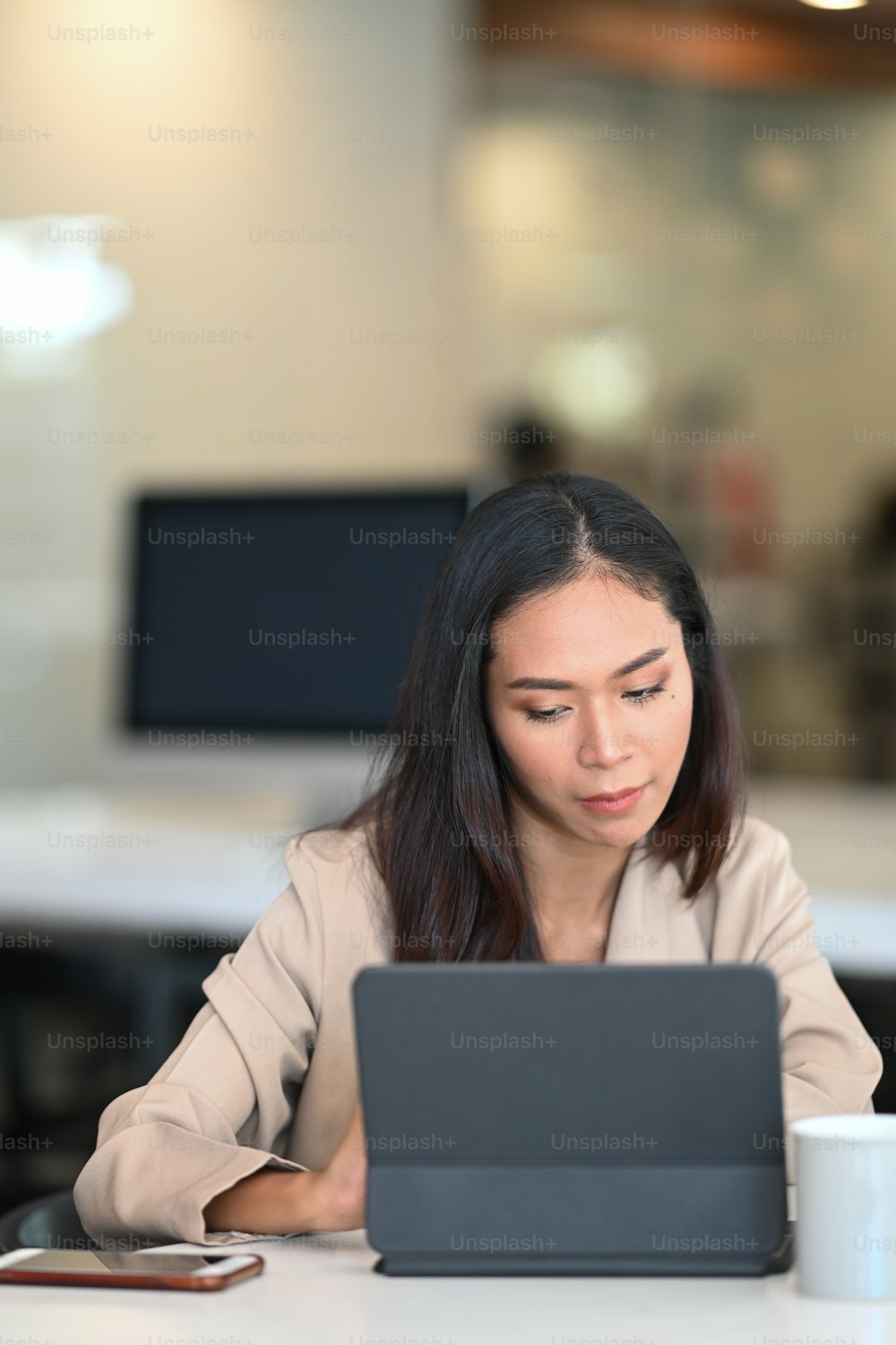 Porträt einer jungen Frau, die am Computer-Tablet arbeitet und im Internet im Büroraum nach Informationen sucht.