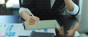 Close up view of businesswoman working with tablet and paperwork on office desk