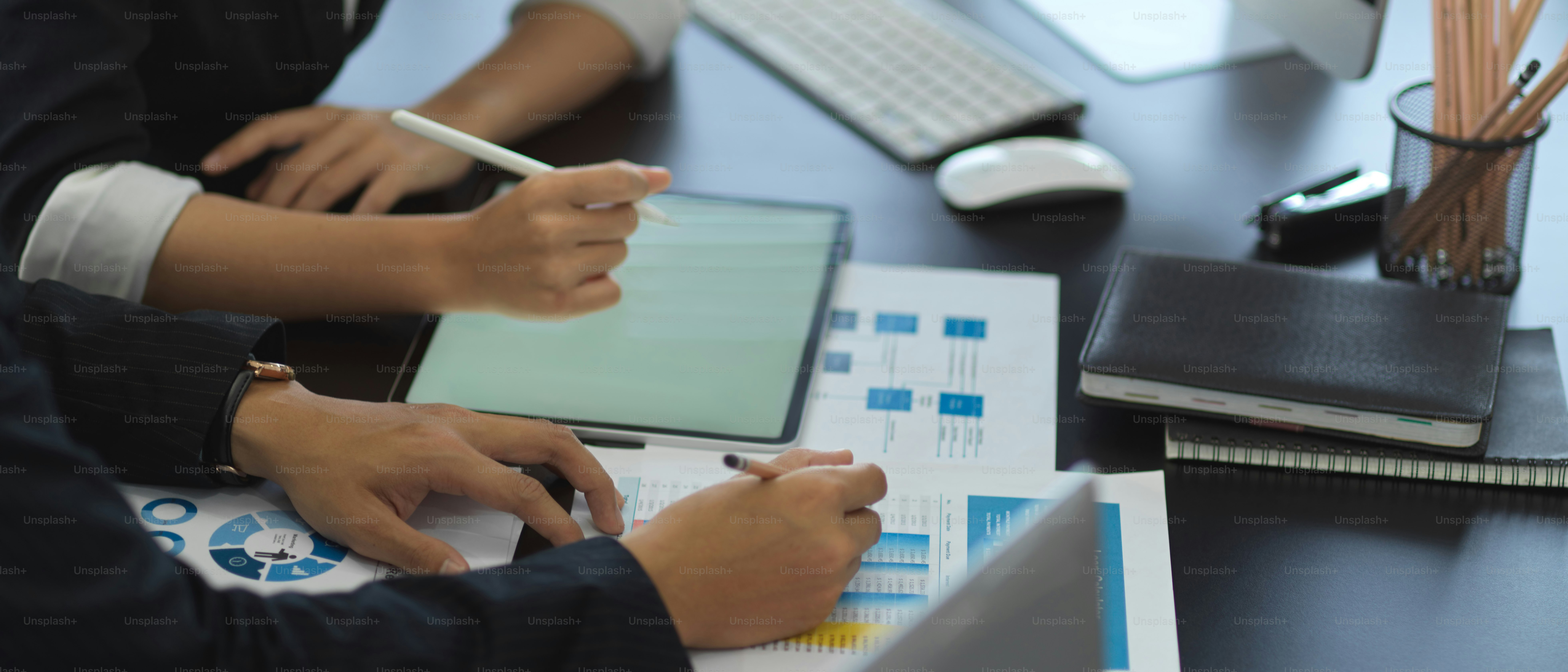 Side view of two businesspeople consulting on their work with business chart and tablet