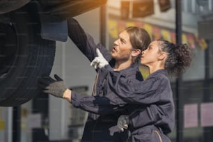 Mechanic examining underside at car service, Auto Repair Service