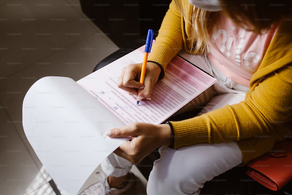 Latin woman hands writing and signing a document or a questionnaire in South America