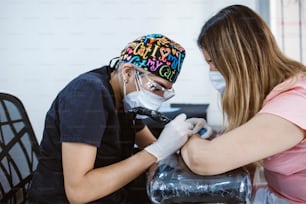 maestro del tatuaggio della donna latina che mostra un processo di tatuaggio di creazione a Città del Messico