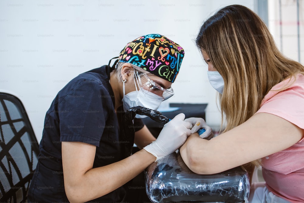 Latin Frau Tattoo Master zeigt einen Prozess der Kreation Tattoo in Mexiko-Stadt