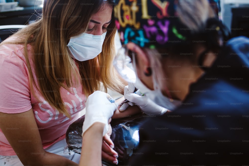 maître de tatouage de femme latine montrant un processus de création de tatouage à Mexico