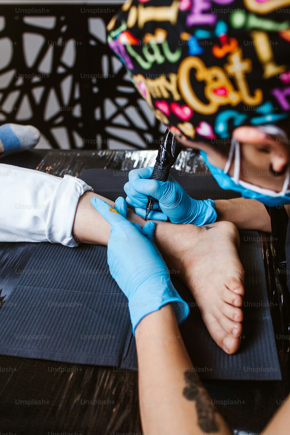 Tatuadora latina demuestra el proceso de tatuarse con pintura y trabaja con guantes estériles azules en la Ciudad de México