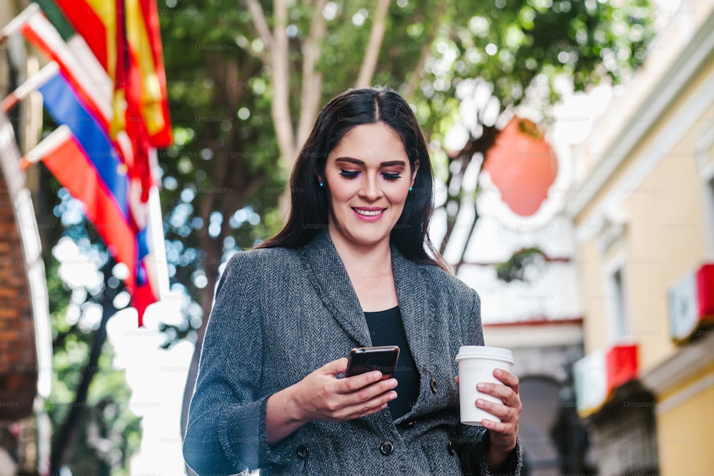 latin business woman in the street with international flag in the background