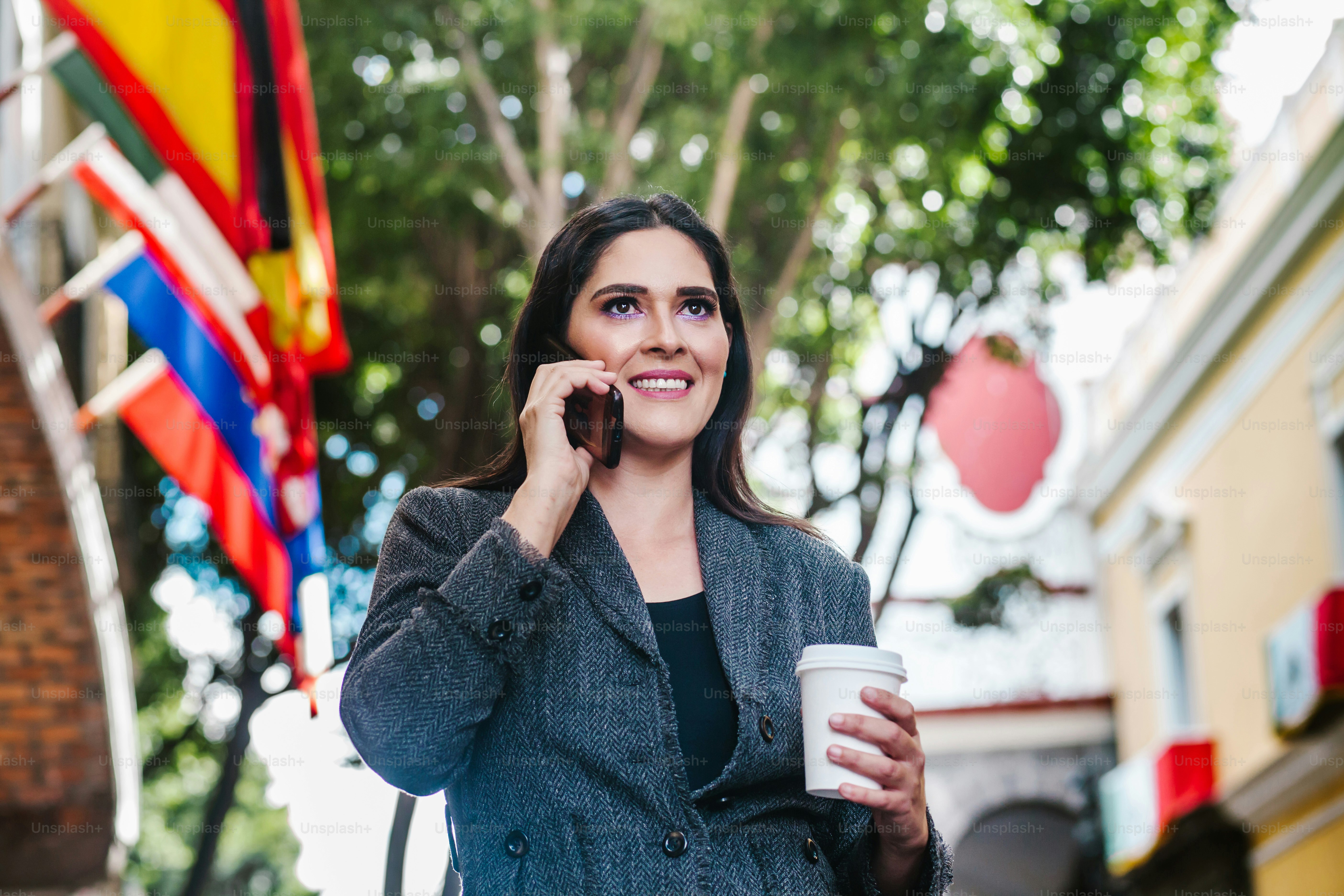 mujer de negocios latina en la calle con la bandera internacional en el fondo