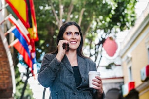 latin business woman in the street with international flag in the background