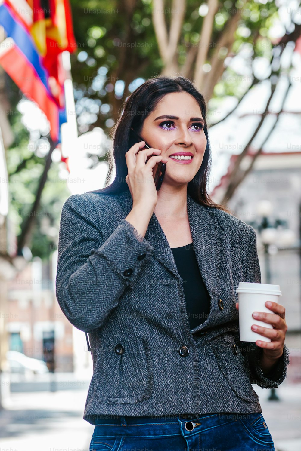 latin business woman in the street with international flag in the background