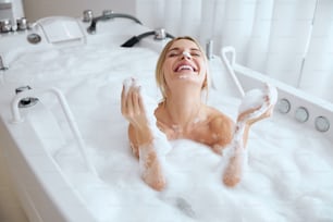 아침에 목욕을 하는 동안 스파 리조트에서 멋진 주말을 보내는 행복한 미소를 짓는 백인 여성의 초상화를 닫습니다.