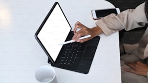 Close up view of female designer holding stylus pen pointing on screen of tablet computer.