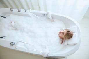 Top view portrait of beauty attractive woman using bubble water spa relaxing body and lying down in bathtub sleeping on bathing time