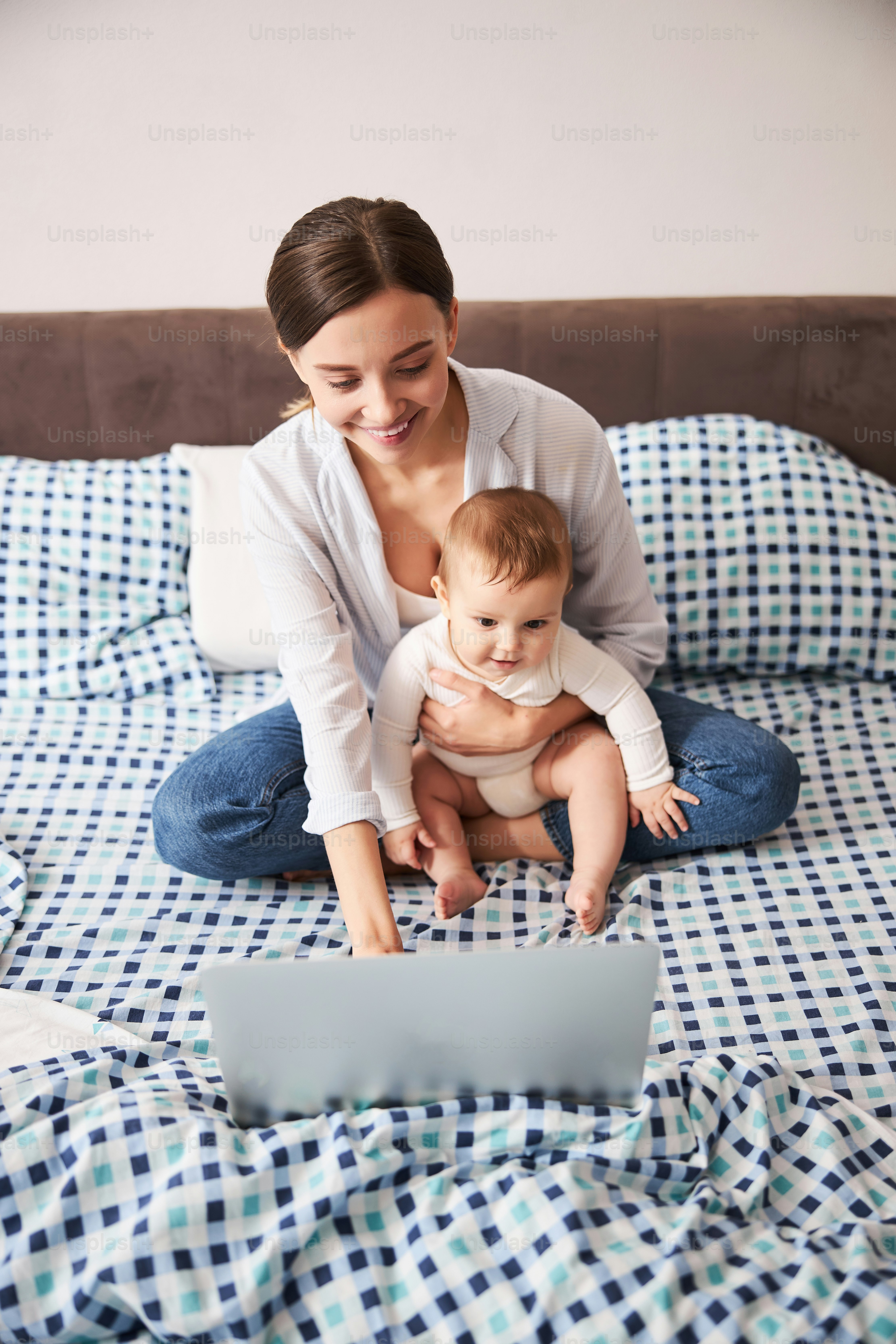 Cute brunette female person keeping smile on her face while having video communication
