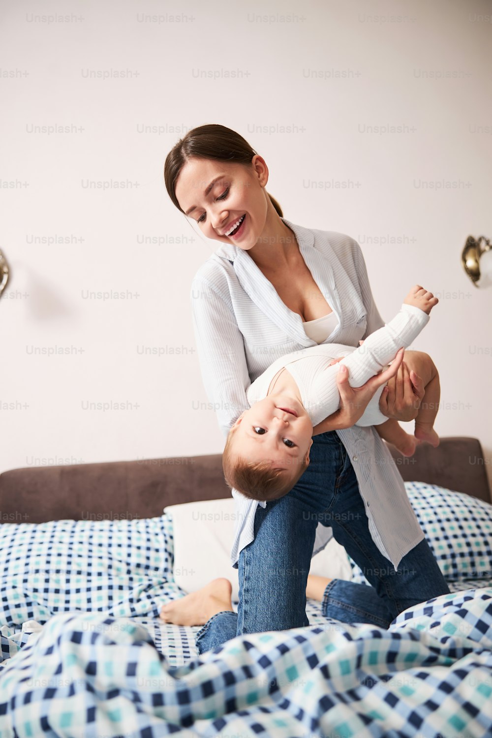 Beautiful female person expressing positivity while playing with her baby boy