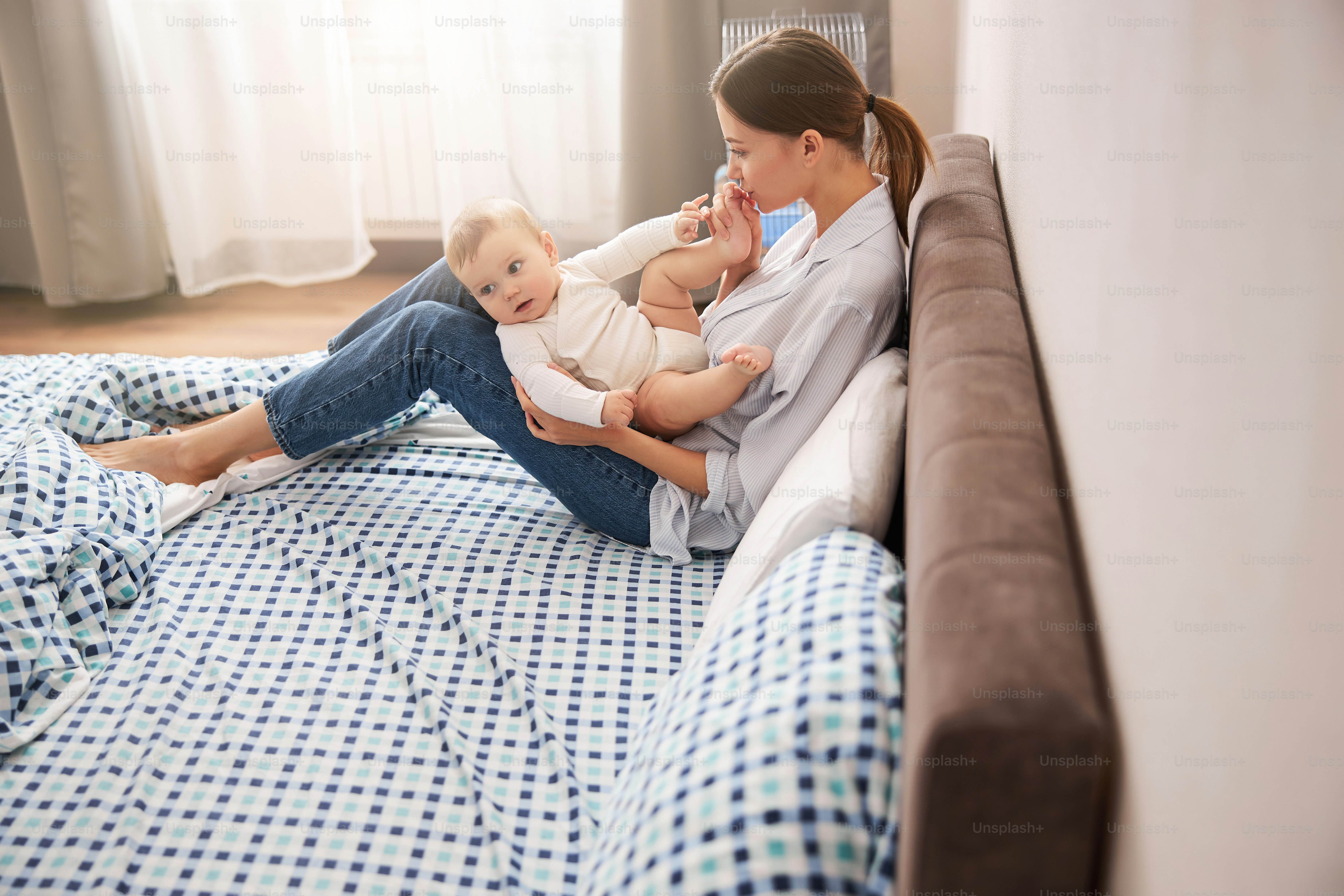 Active baby looking aside while paying attention on something that moving on the background