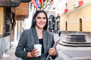 Donna d'affari latina nella strada con la bandiera internazionale sullo sfondo