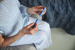 Cropped photo of a lady covering an empty syringe with a case in her hands