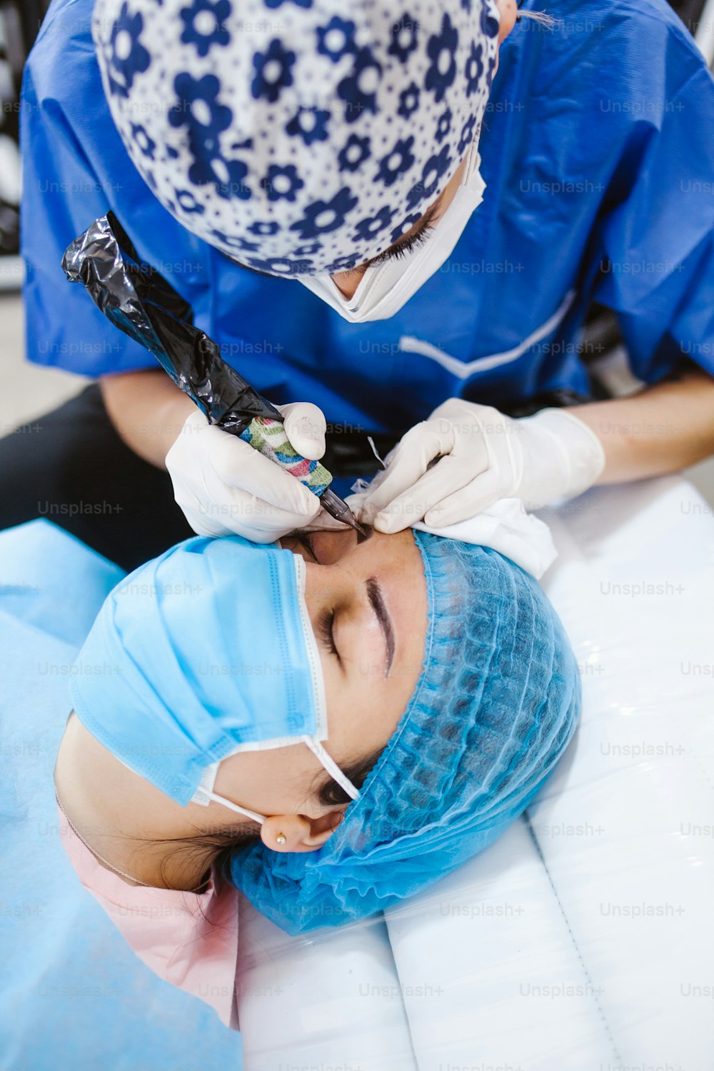 Latin Cosmetologist preparing to mexican woman for eyebrow permanent makeup procedure in Mexico, Microblading closeup