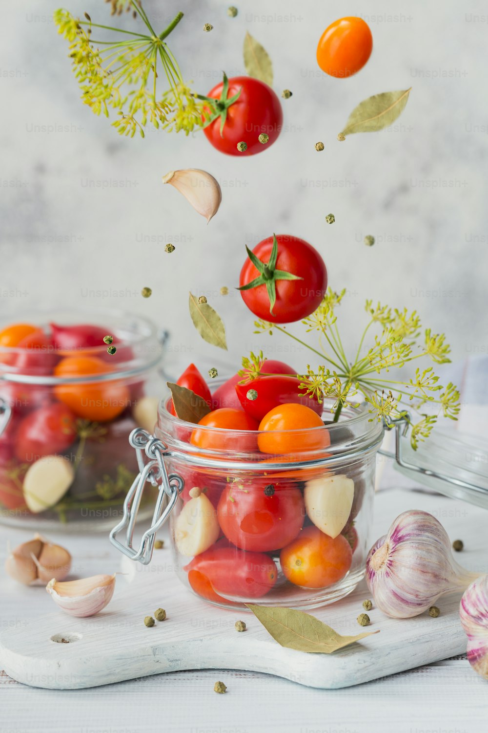 Fliegende Zutaten für gesundes veganes Essen. Eingelegtes Gemüse. Tomaten werden zum Konservieren vorbereitet. Clean Eating, vegetarisches Food-Konzept