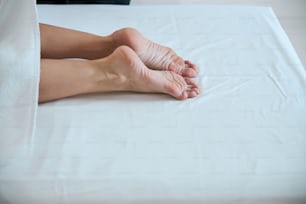Close up portrait of beautiful female feet on the white massage table in beauty clinic