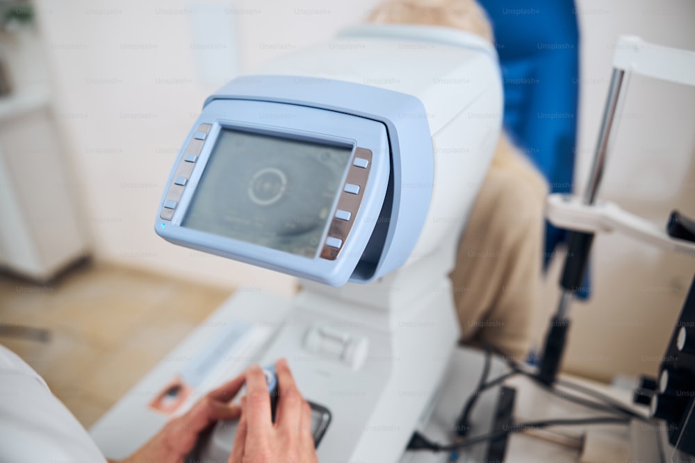 Beschnittenes Foto einer Augenärztin mit dem berührungslosen Tonometer für die Augeninnendruckmessung