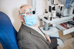 Senior Caucasian male patient wearing the trial frame and the occluder over his left eye